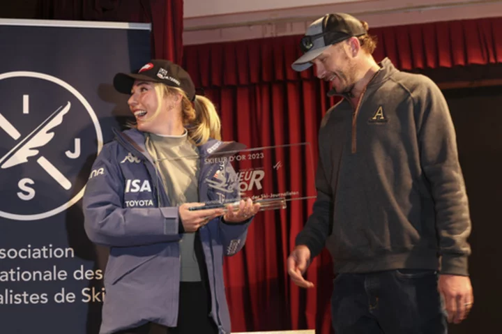 Shiffrin named 'skier of the year' for the 3rd time. She receives the trophy from Bode Miller