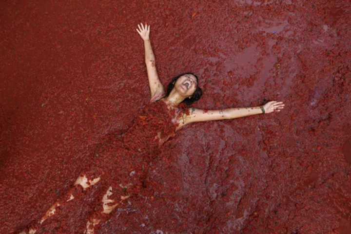 Revelers hurl tomatoes at each other and streets awash in red pulp in Spanish town's Tomatina party