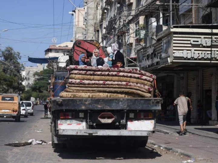 Tens of thousands flee south in bombarded Gaza as Israeli troops gather near border