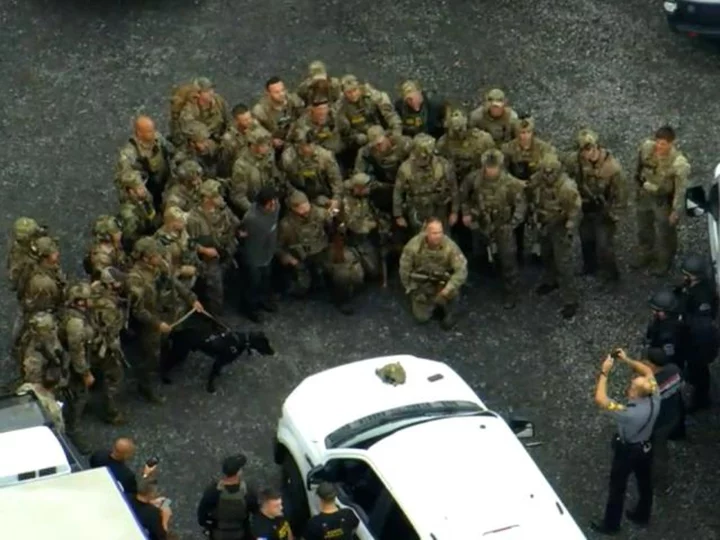 Police official defends officers' group photo with captured fugitive: 'They're proud of their work'