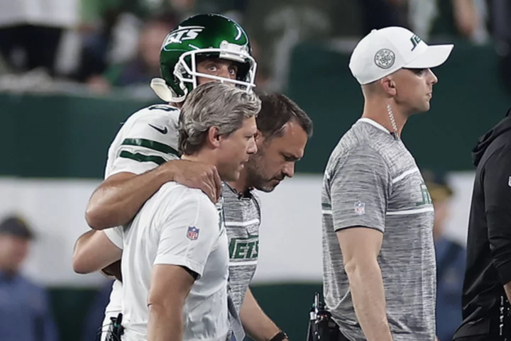 Aaron Rodgers carted from sideline after suffering apparent leg injury in his first series for Jets