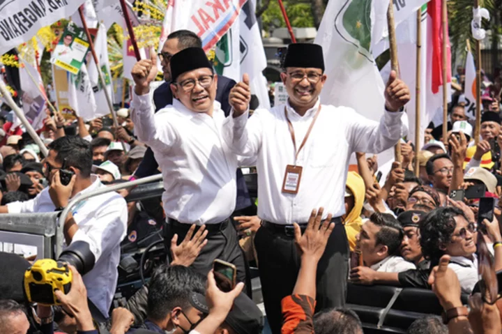 Indonesian presidential candidates register for next year's elections as supporters cheer