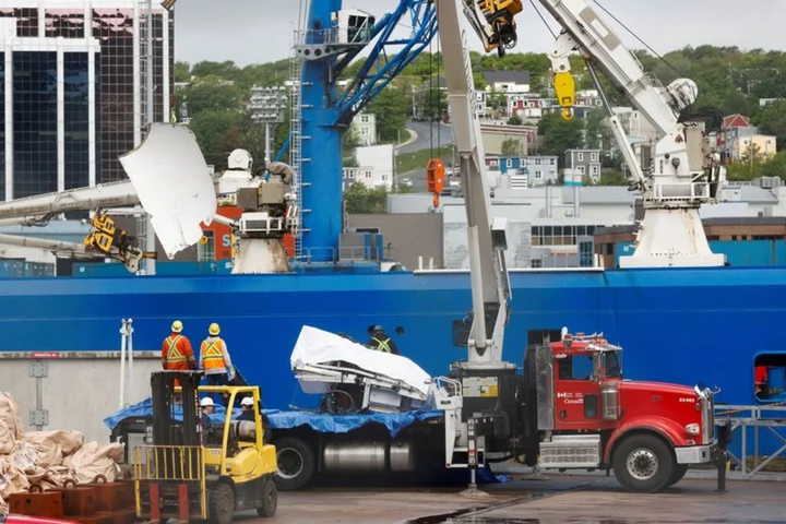 Presumed human remains and shattered Titanic submersible returned to shore